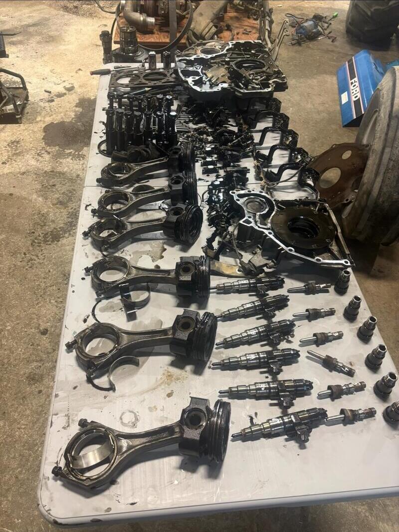 Pistons and connecting rods laid out on a bench during a rebuild